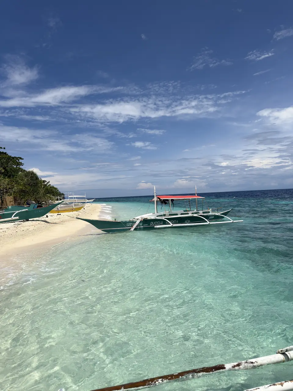 Barca tradicional filipina sobre el agua turquesa frente a la isla de Balicasag