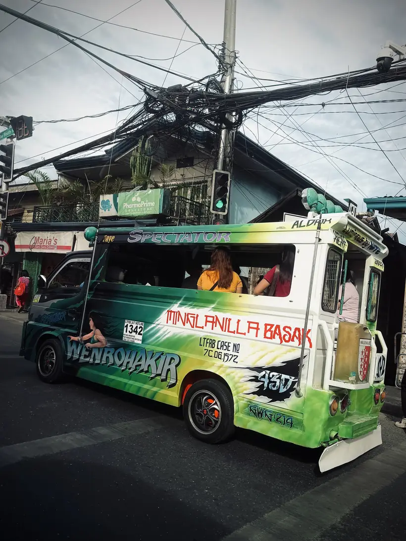 Jeepney decorado entre cables y semáforos