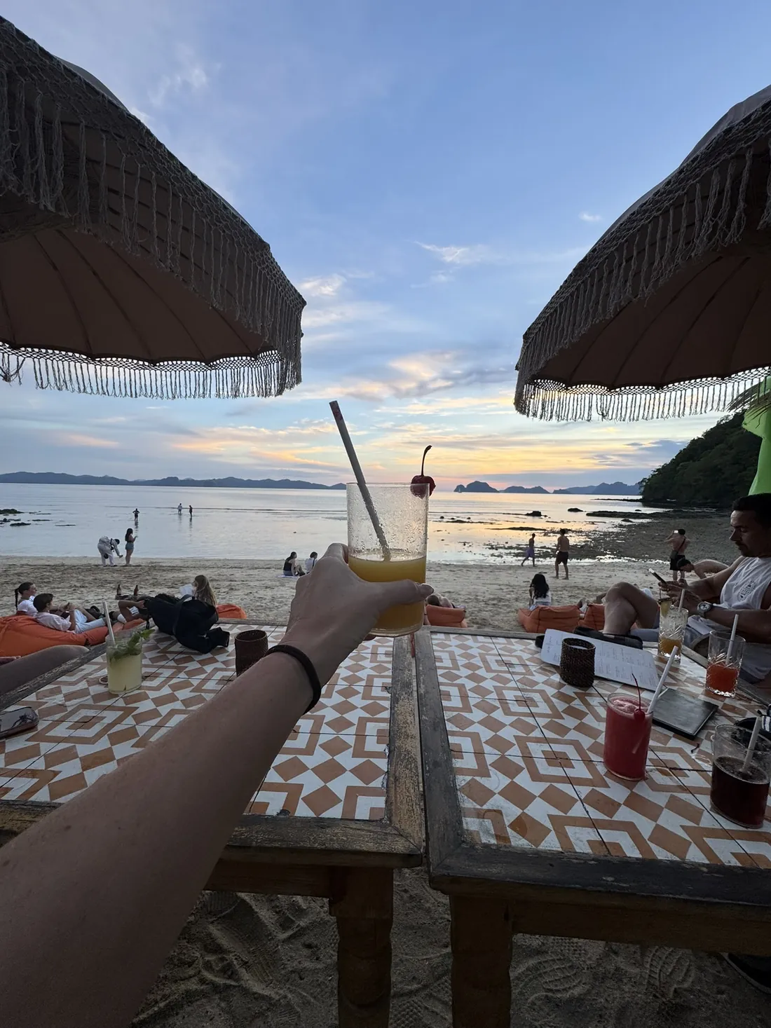 Cóctel de mango en una mesa de Las Cabañas, frente a la playa al atardecer