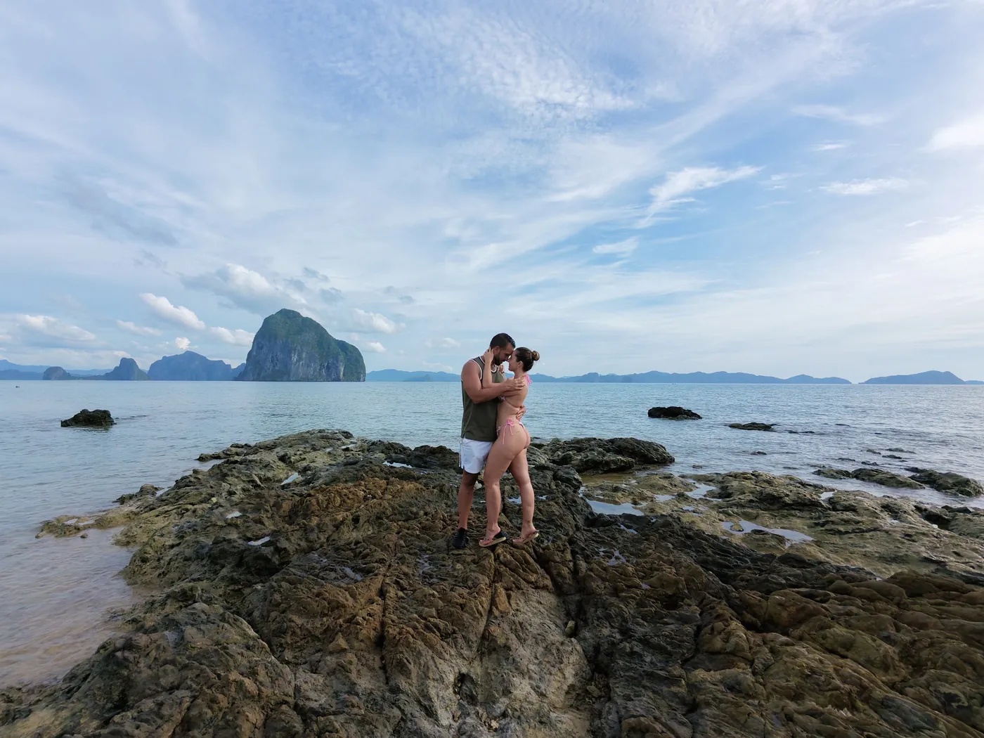 Cristina y Juan junto al mar con los acantilados de El Nido al fondo