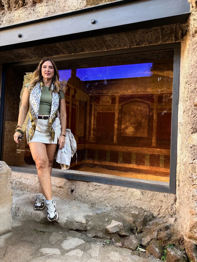 Cristina ante una estancia con pinturas murales protegida por un cristal en el Palatino